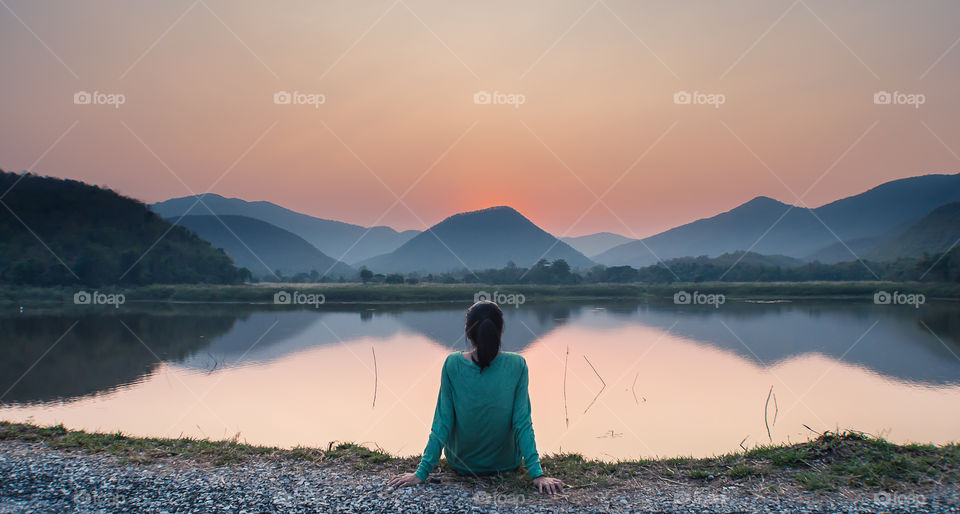 a young woman watching sunset alone