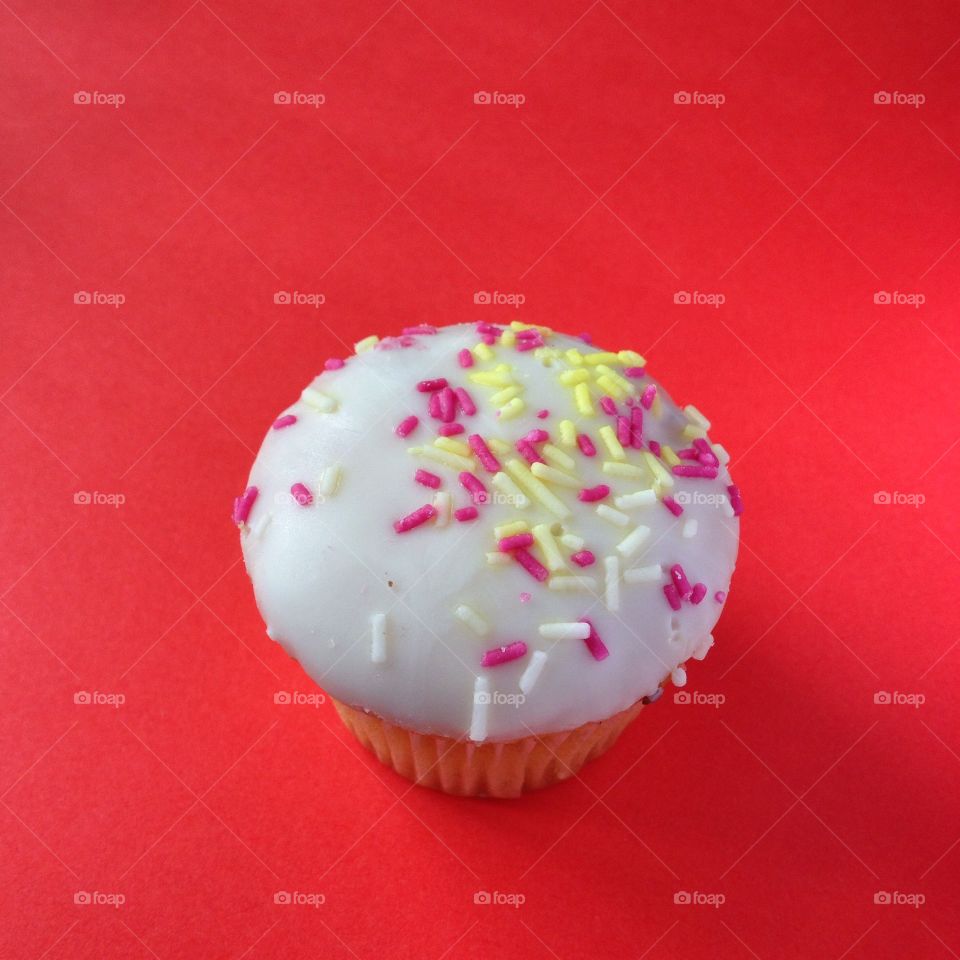Cupcake. A white cupcake on a red background