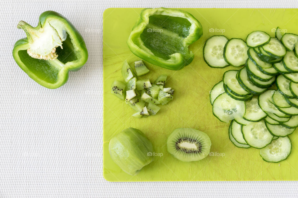 Green fruit and vegetables on copping board