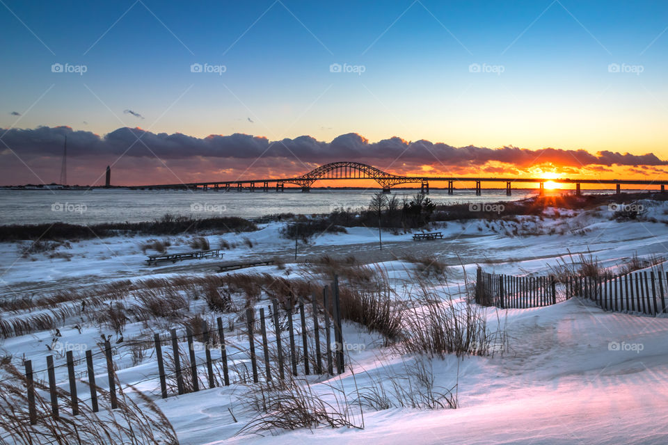 Snowy landscape at the beach during sunset.
