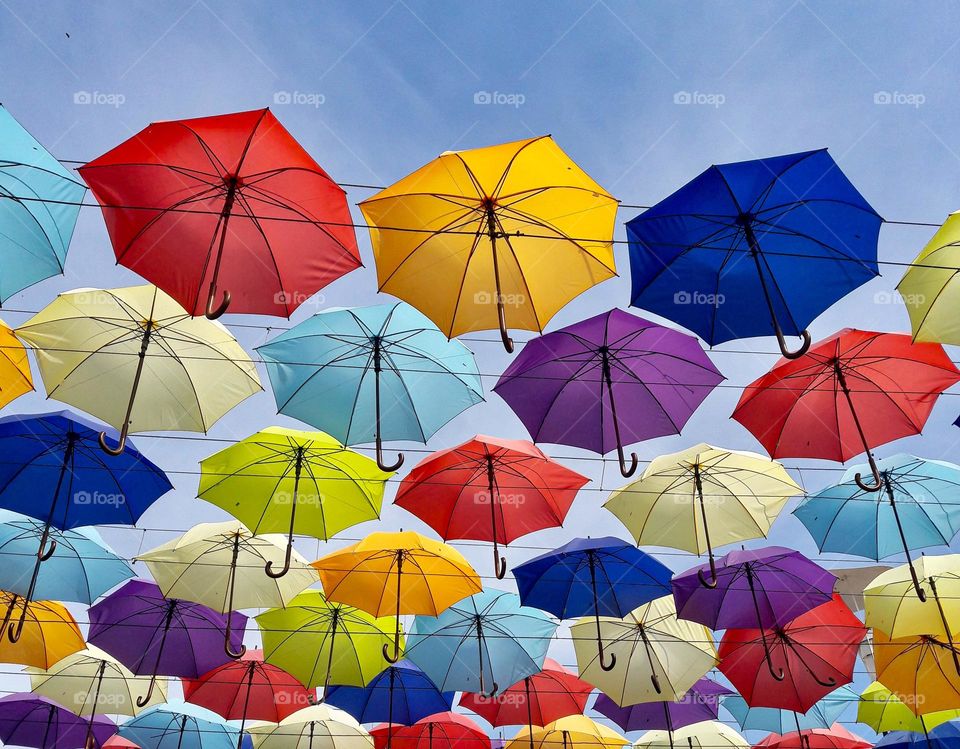 Colorful umbrellas against blue sky 