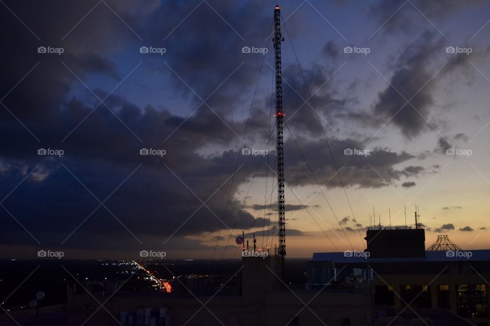 A sunset picture on top of a building in construction of a tower