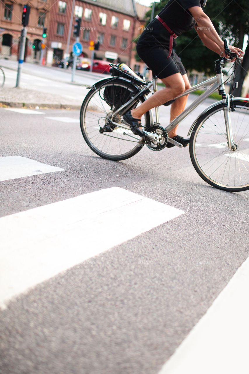 Woman riding bicycle over pedestrian crossing