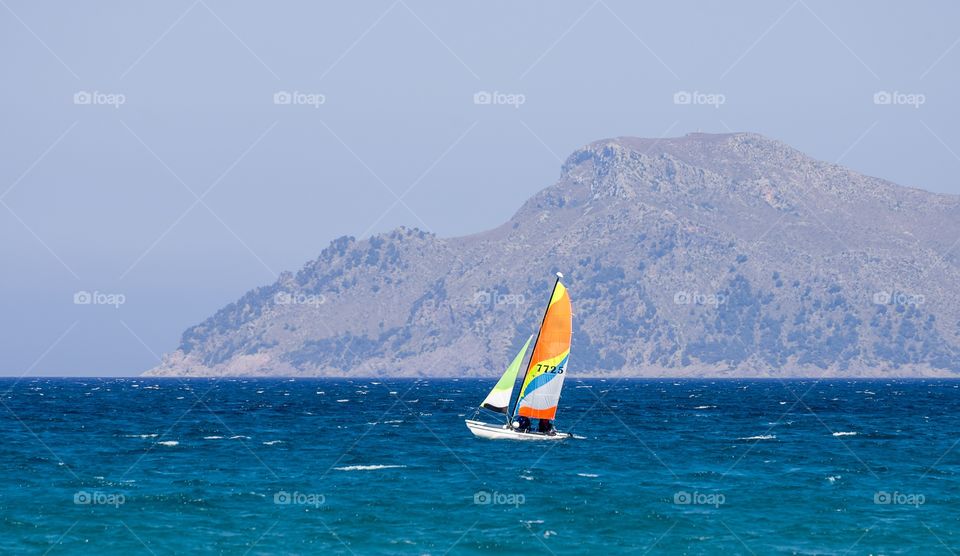A small sailing boat in Alcudia bay near Can Picafort town, Majorca, Balearic Islands, Spain