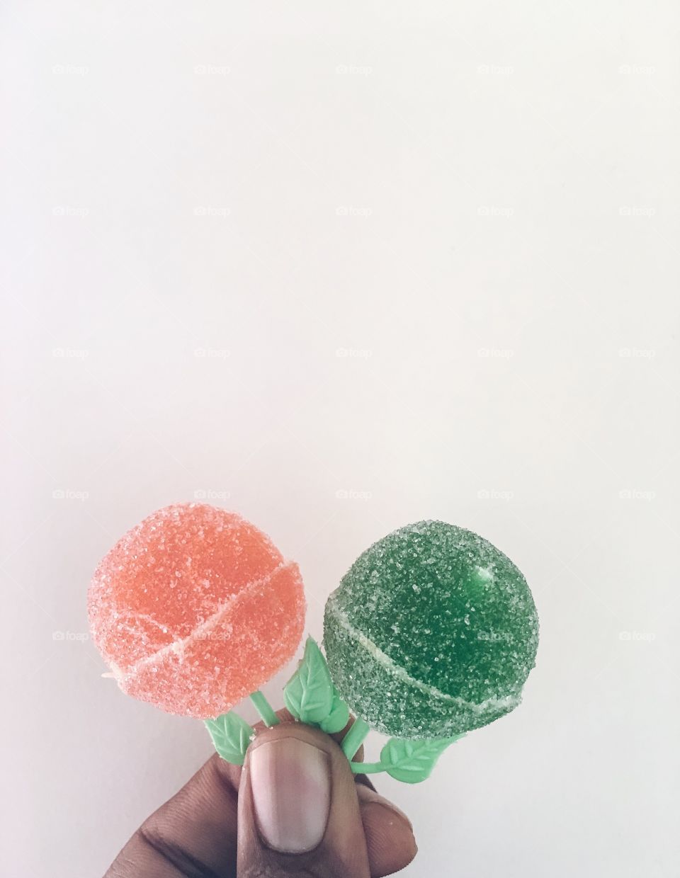 Person holding lollipop against white background