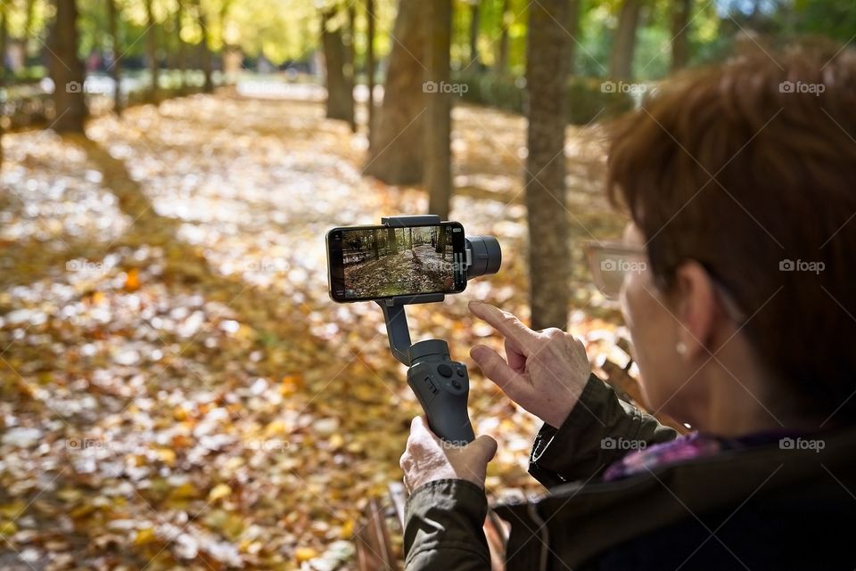 Mature woman records video with her smartphone on a gimbal 