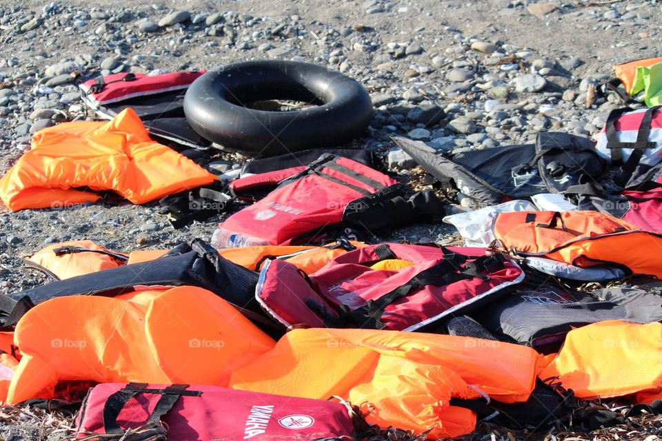 Greek island pile of lifejackets rubber rings on the beach facing Turkey