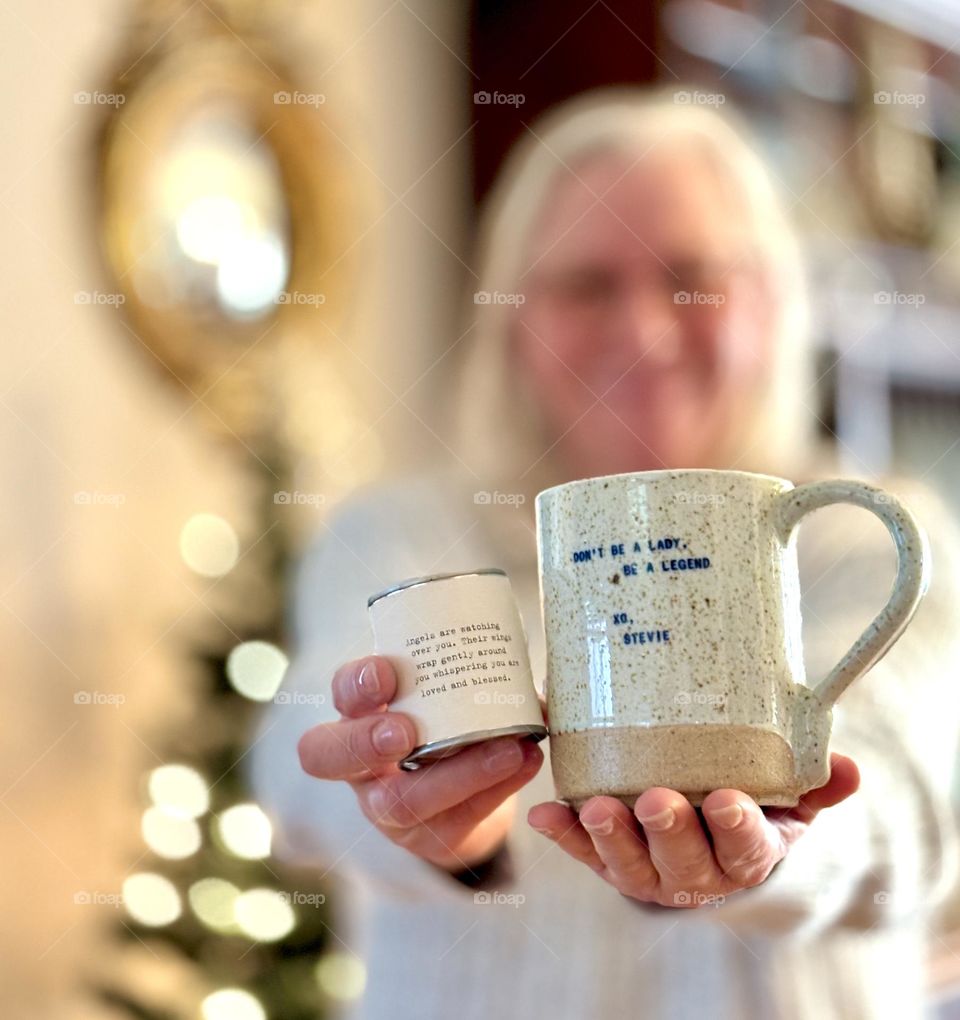 Giftgiving for Christmas and the holidays, blurry woman in background holding outstretched hands with gifts