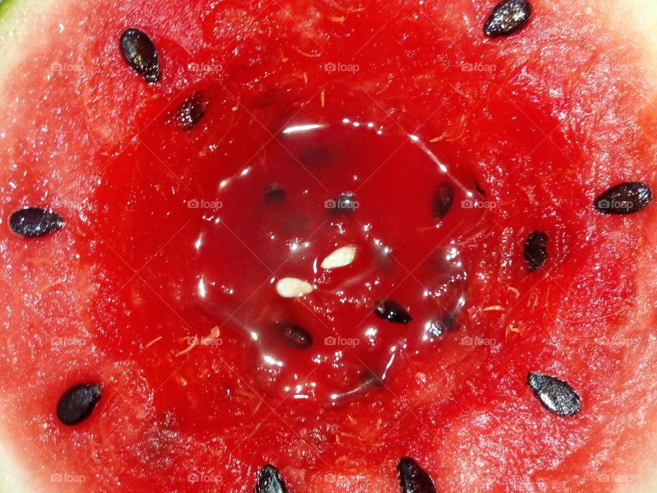 Macro red juicy sweet Watermelon with lots of black seeds