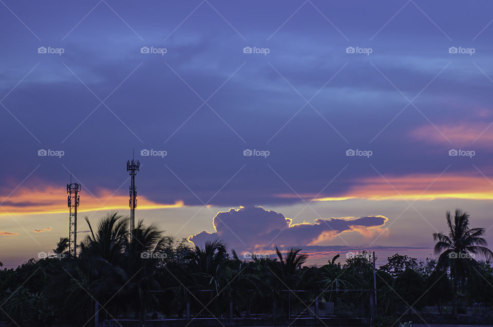 Evening sunset light is orange after the telephone receiver antenna.