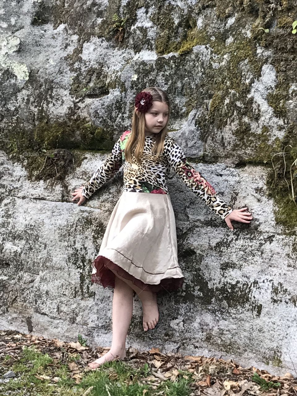 Pretty girl standing near rock