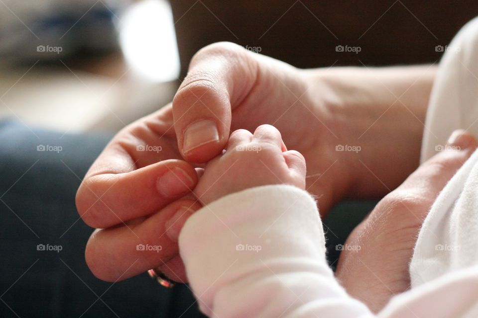 Close-up of new born baby and mother holding hands