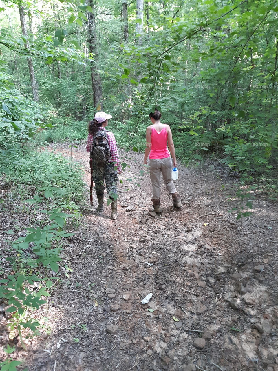 Hiking on a trail amongst the trees with a buddy is a great way to stay in shape