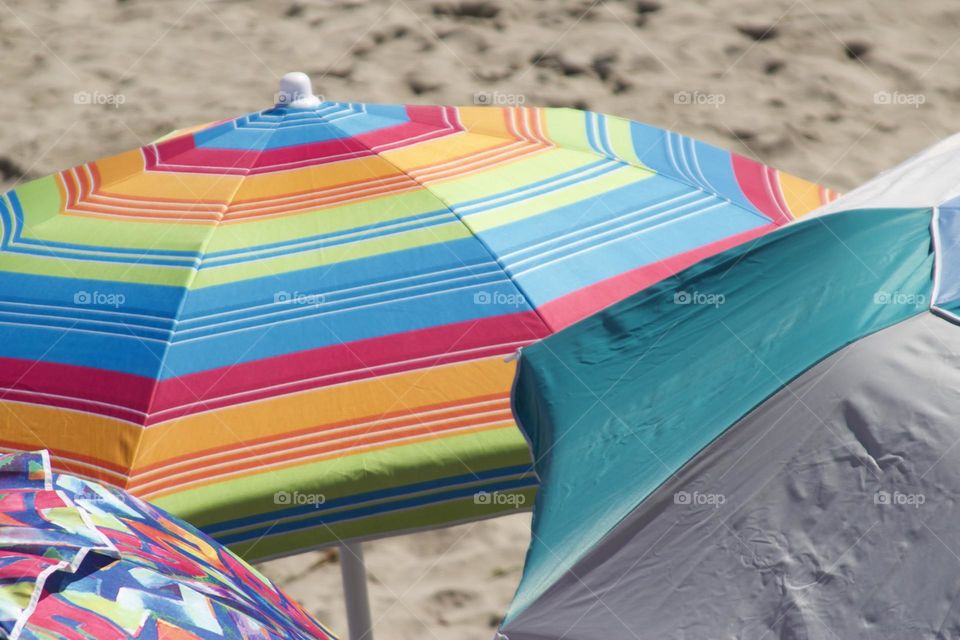 Colorful beach umbrellas in Capitola California, warm sand enjoying the day in sunny California 