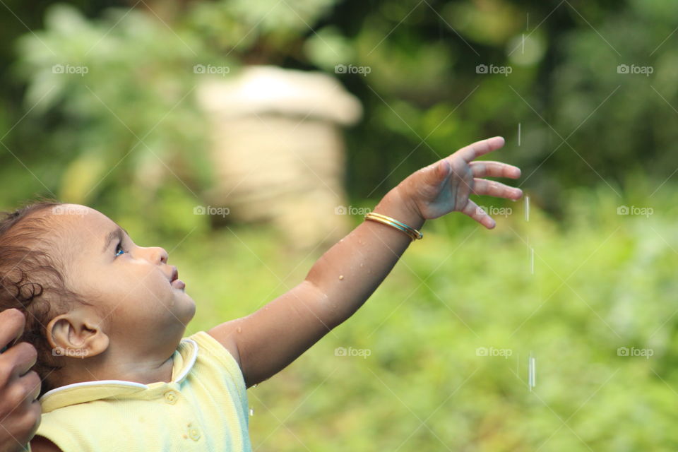 rainy days, little baby girl enjoying with rain drops.