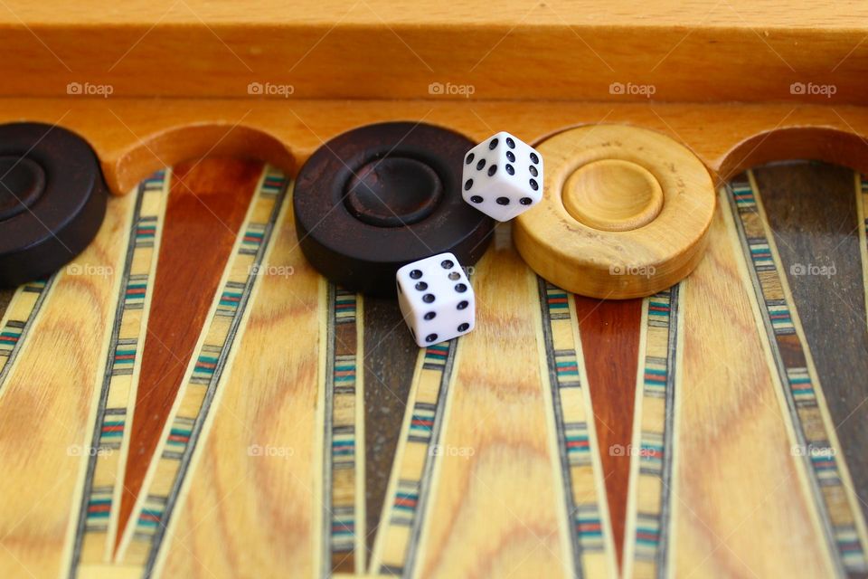 backgammon gambling two pawns Black and white stand side by side one of the dice shows six and the second shows both five and six. incomprehensible situation in the game. two square two round objects.