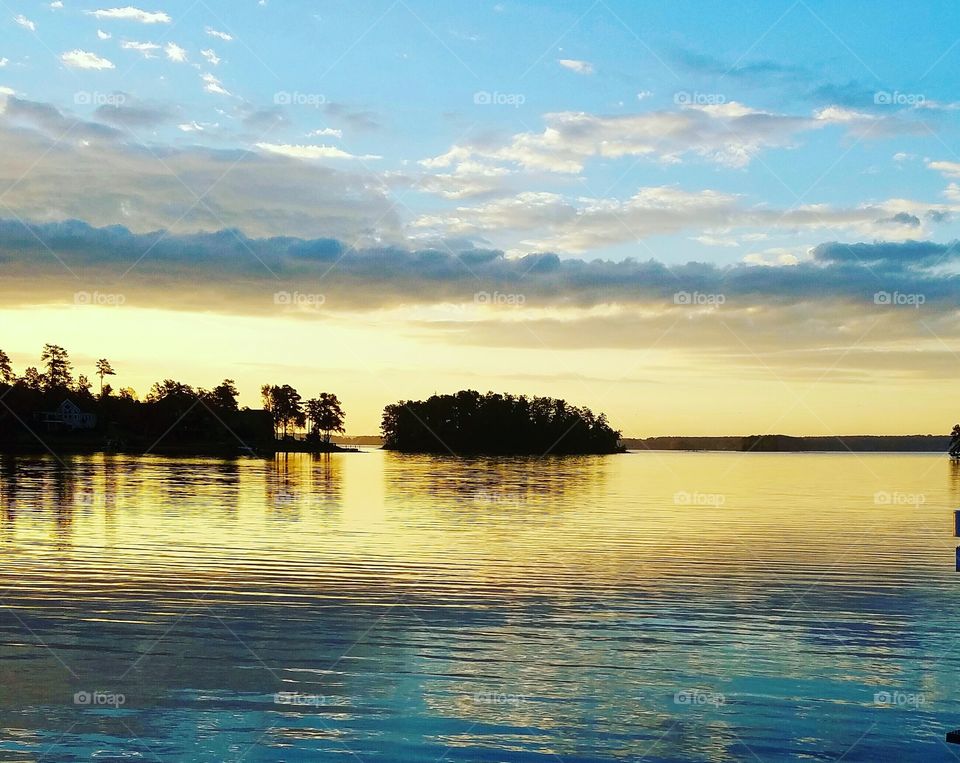 morning sun reflecting off of clouds on lake