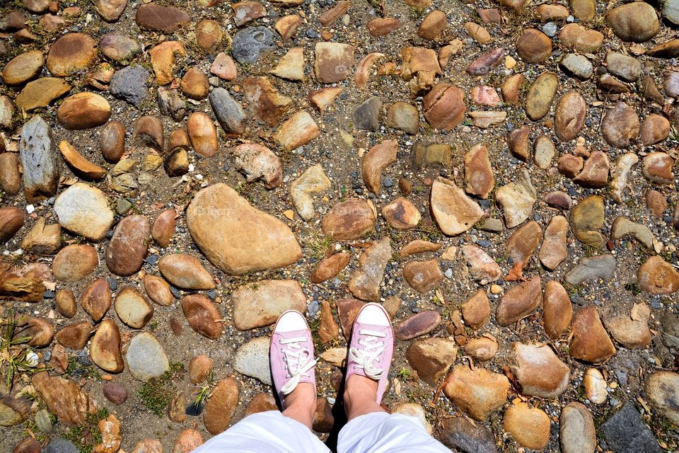 Sneakers walking on old cobblestone street