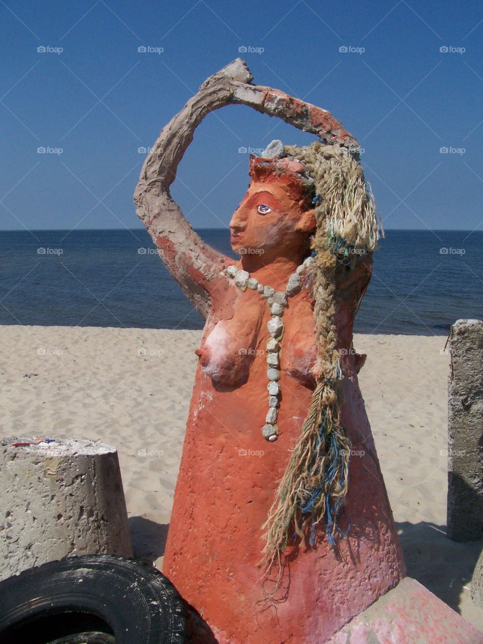 Sculpture of a woman on a beach by the sea 