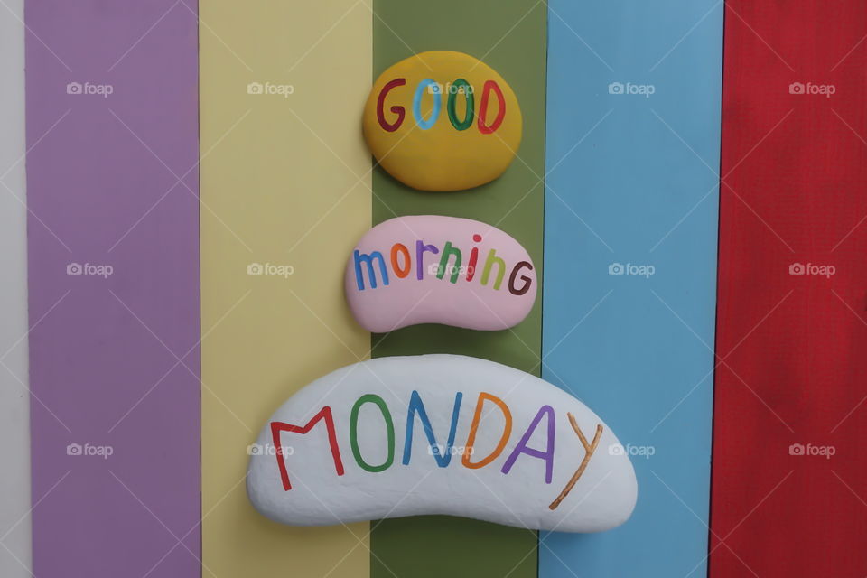 Good Morning Monday, best beginning greet for a great first day of the week with colored stones and rainbow colored wooden board