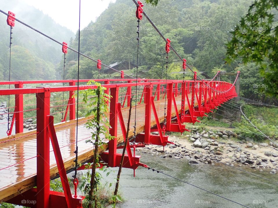 Red suspended bridge in the fog