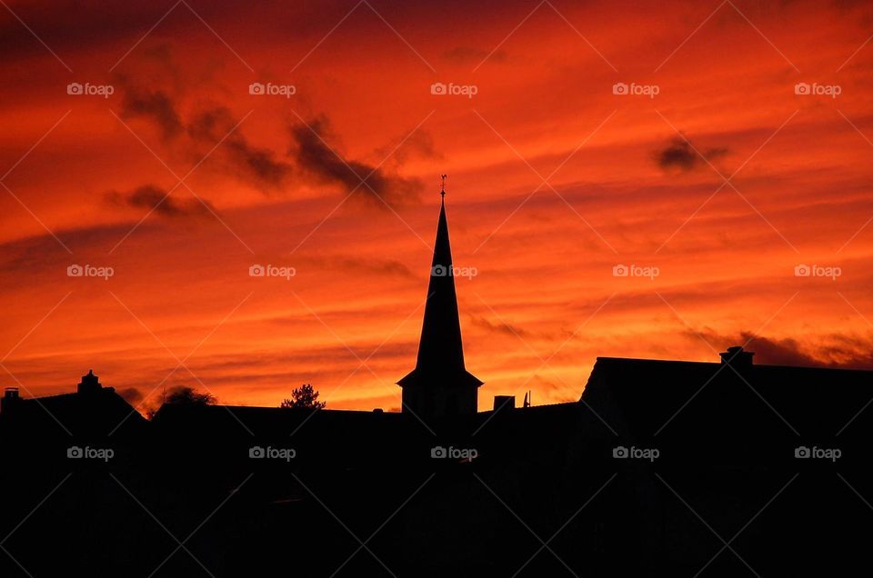 The sun sets on a church in Wittlich-Bombogen, Germany. 