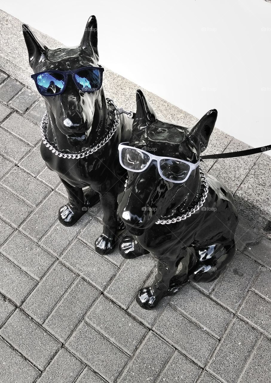 Black plastic dog sculptures wearing glasses