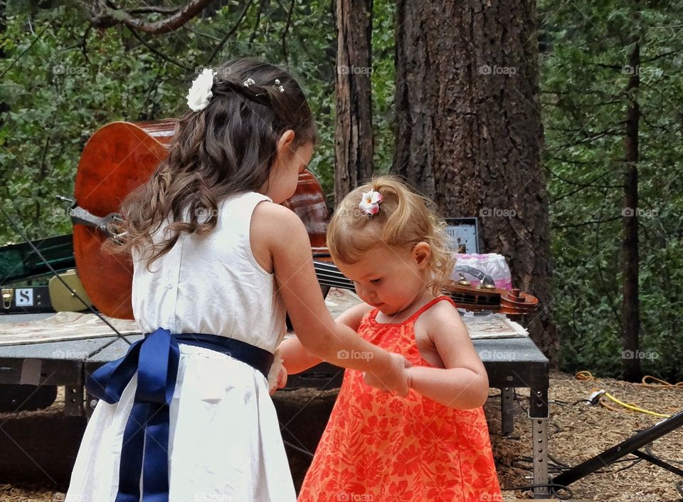 Learning To Dance. Young Girl And Her Toddler Sister On The Dancefloor
