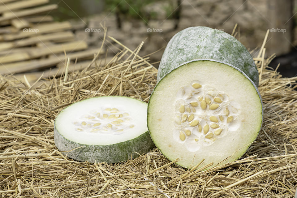 Winter melon is cut into pieces on the straw.