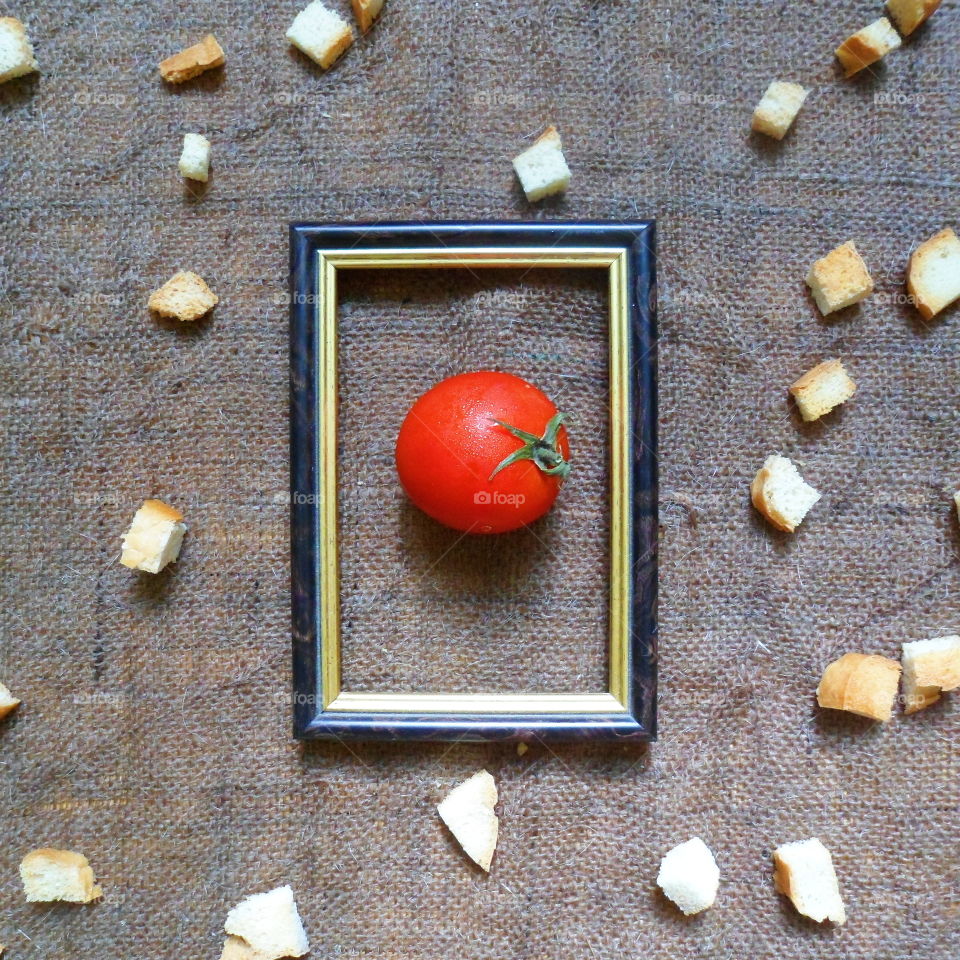 red tomato in a frame on a background of white crackers