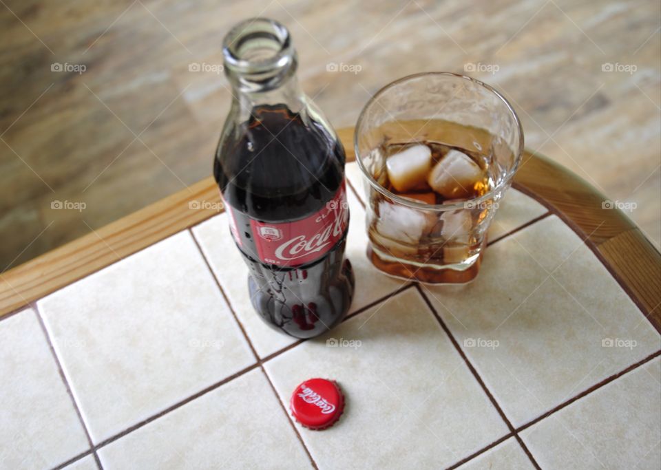 A bottle of Coca-Cola and a glass are on the table