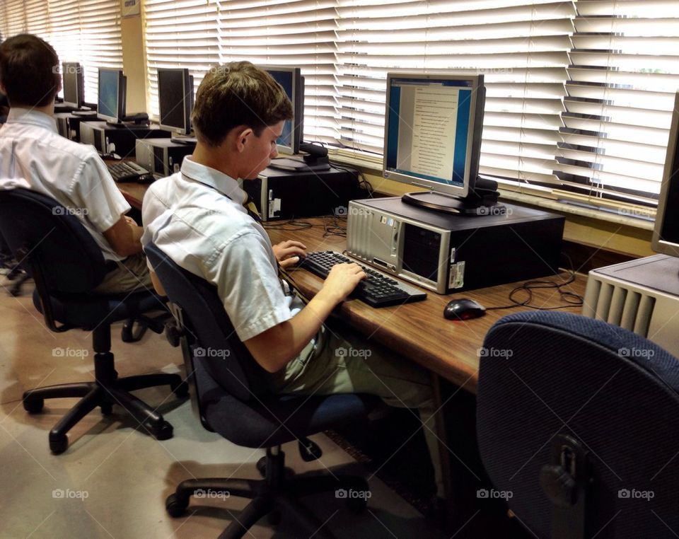 Student with computer in school library