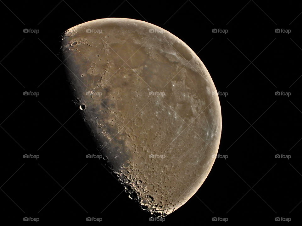 Half moon with illuminated edges and craters towards the dark side