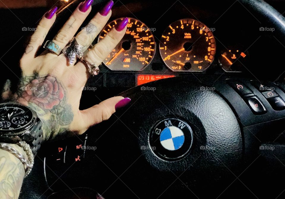 BMW M3 steering wheel and tattooed manicured hand 