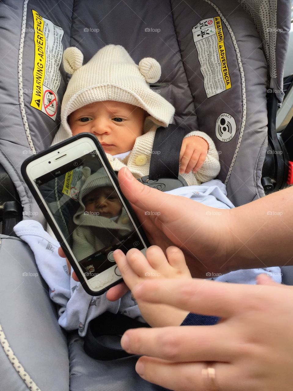 Toddler taking photo of his baby brother 