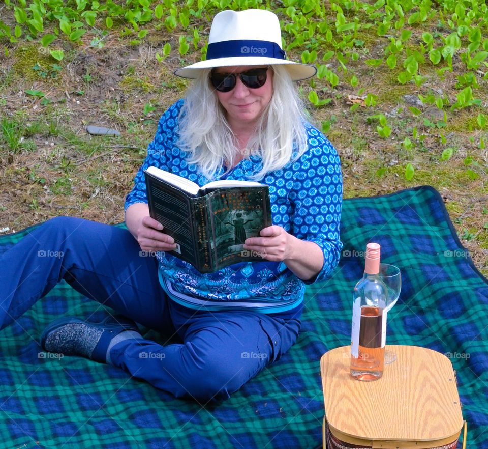 Picnic in the park, woman, reading with a picnic basket, urban setting