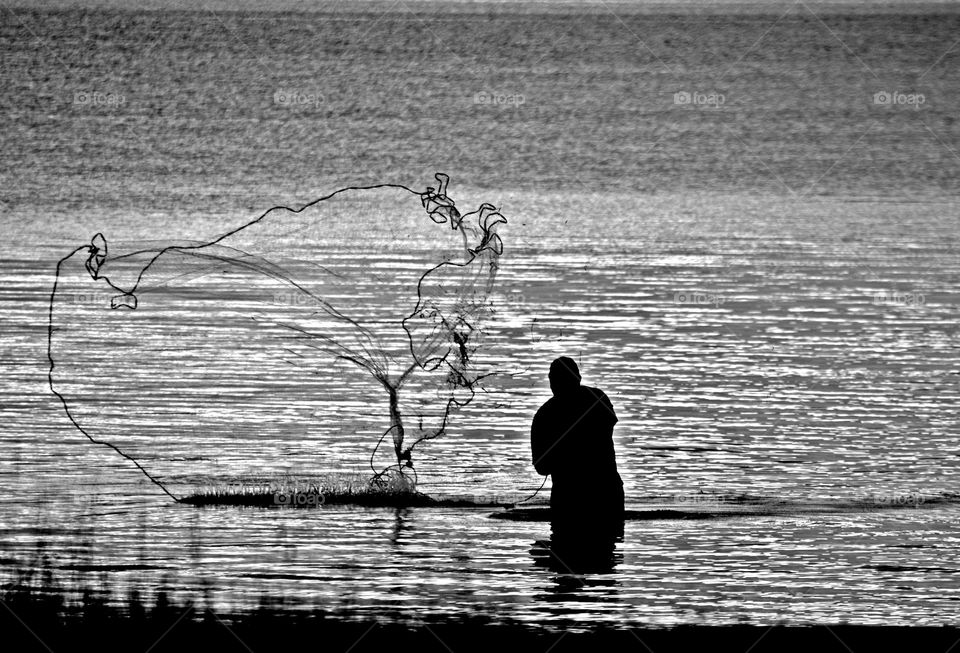 A fisherman casting a net - A casting net, also called a throw net, is a net used for fishing. The net is cast or thrown by hand in such a manner that it spreads out while it's in the air before it sinks into the water.