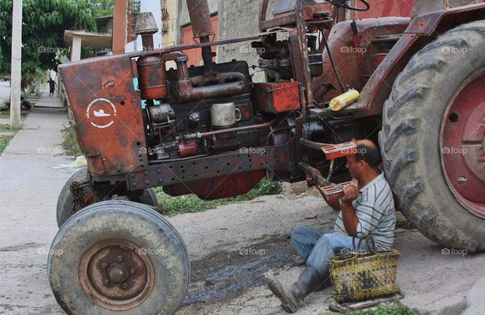 Man Fixing A Tractor