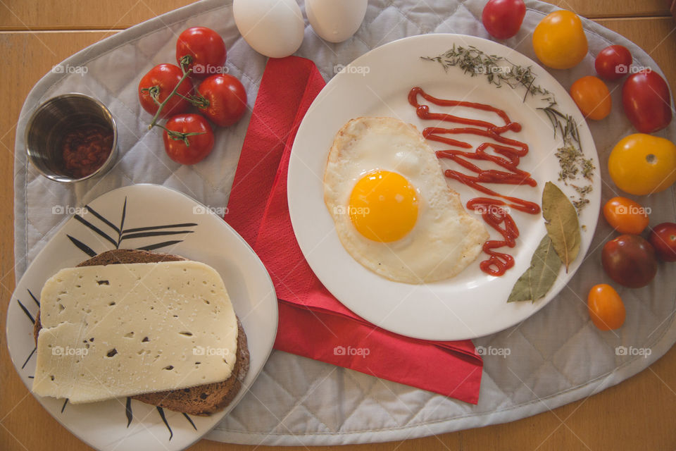 Eggs, tomatoes, bread and cheese in a beautiful bright flat lay