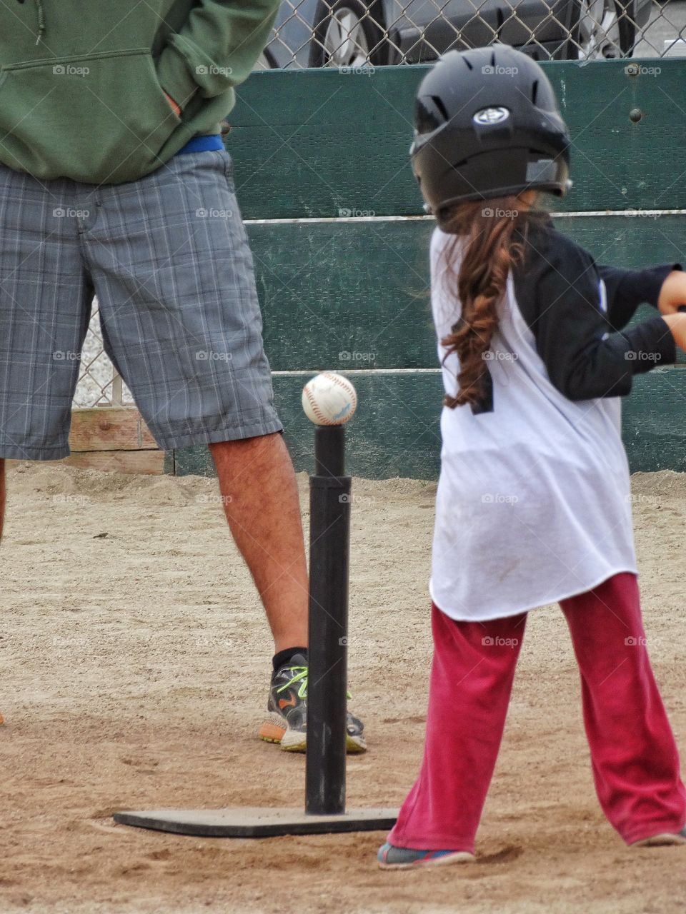 Girls In Sports. Young Girl Swinging At A Baseball
