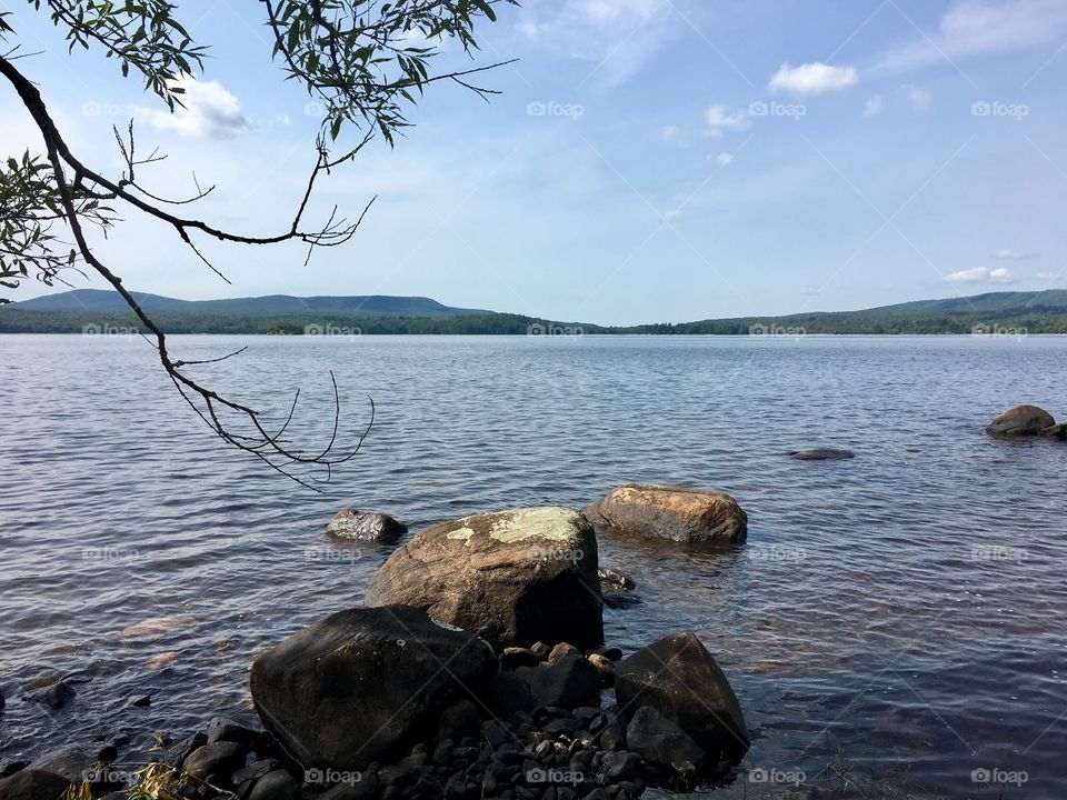 Rocks in calm lake in the Adirondack mountains. 