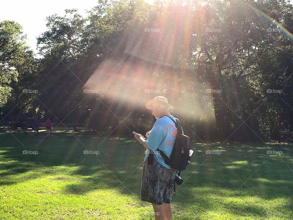 Summer sunbeams surrounding hiker.