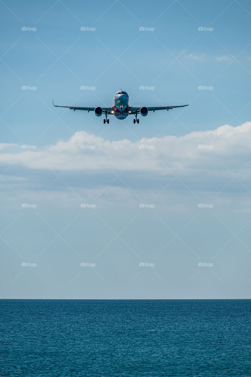 Airplane landing into port at Beautiful sea scape view in the southern of Thailand