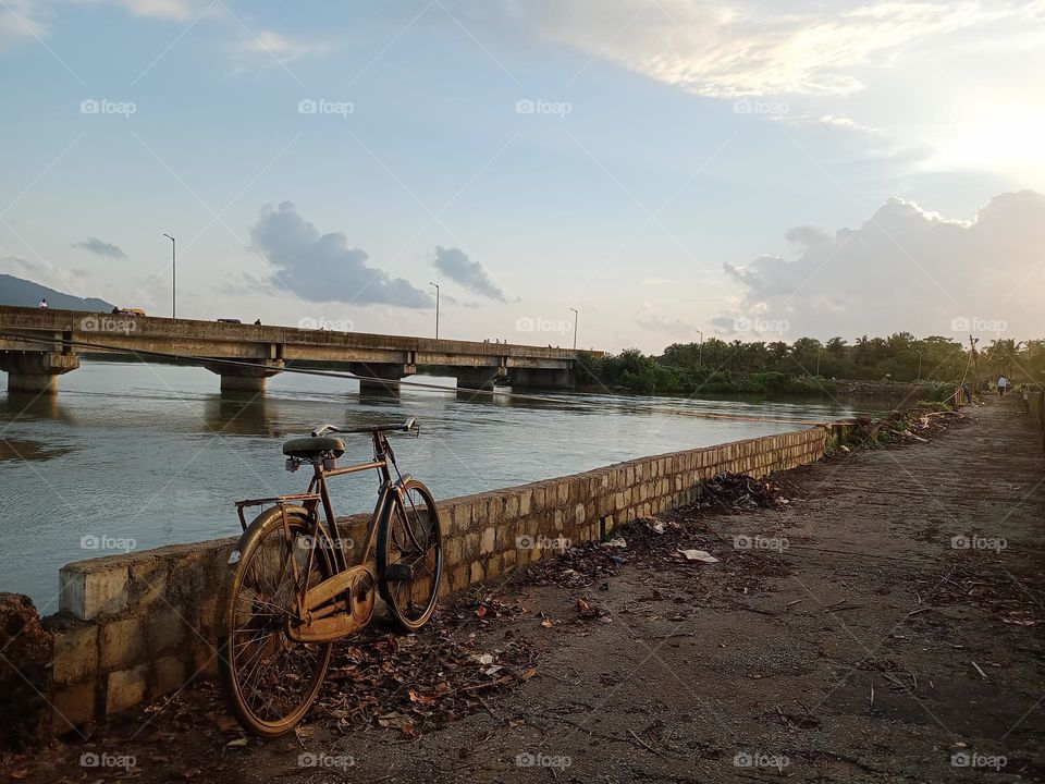 old bicycle with nice background blue sky water bridge sunset time in village side