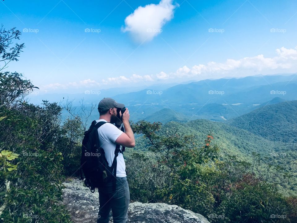 Man taking a photo of the beautiful scenic Smoky Mountains 