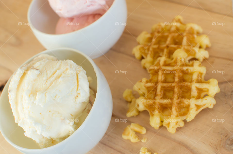 Ice cream scoops in bowls on wood table