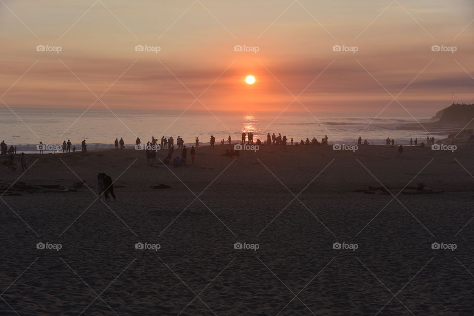 Silhouette of people enjoying sunset on a beach
