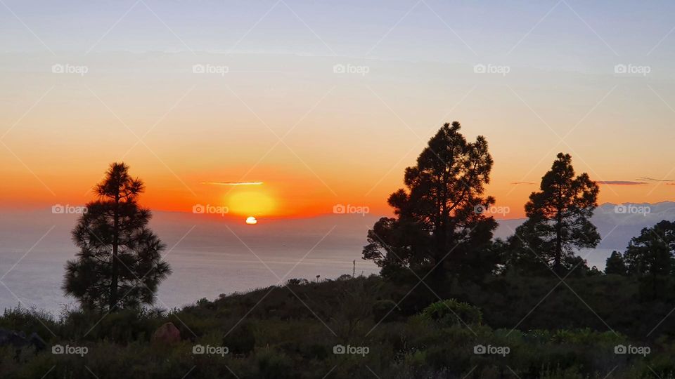 sunset in the Mountains with a view over the clouds and the colorful sun going down