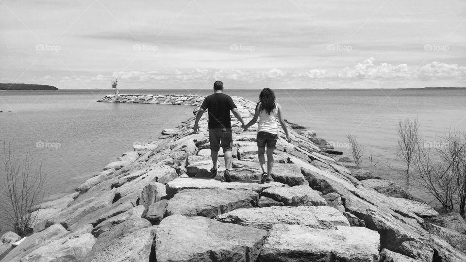 couple walking stone pier