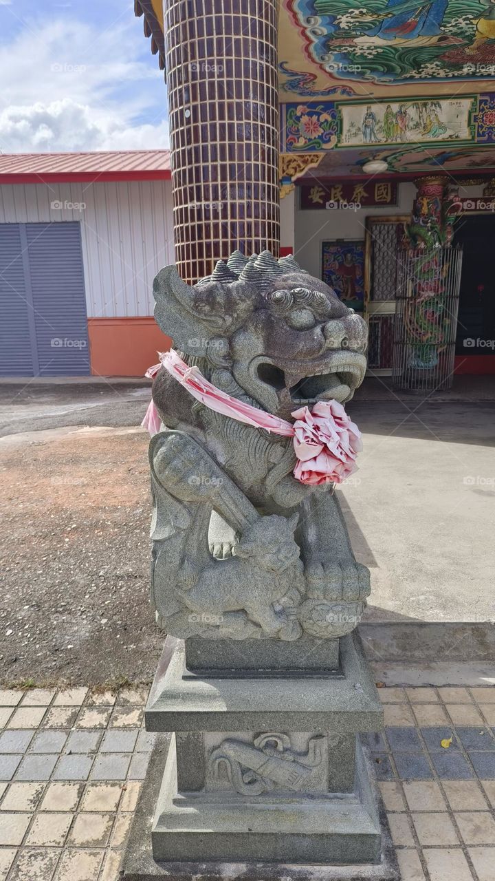 Statue of a lion at the entrance to the temple.